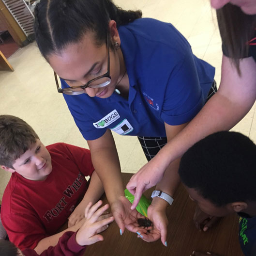 Undergraduate Sara Alvarez showing off a Madagascar hissing cockroach to 4th graders at Fort White Elementary. 